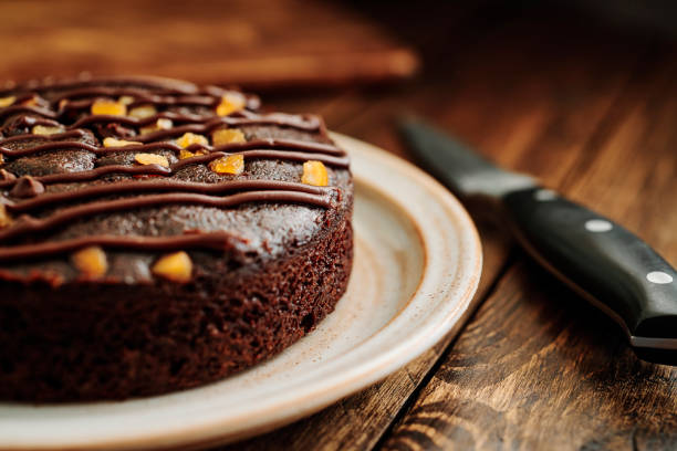 Chocolate and Orange Cake on a rustic plate on a dark wood table.