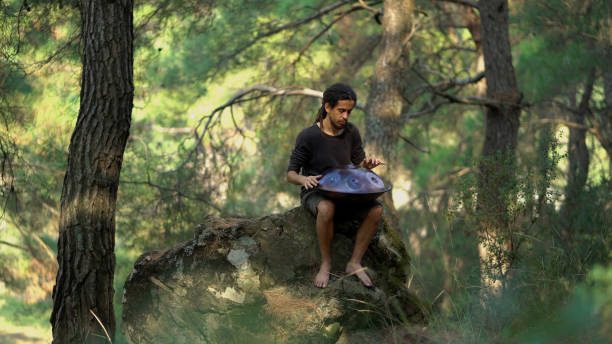 Musician playing handpan in forest