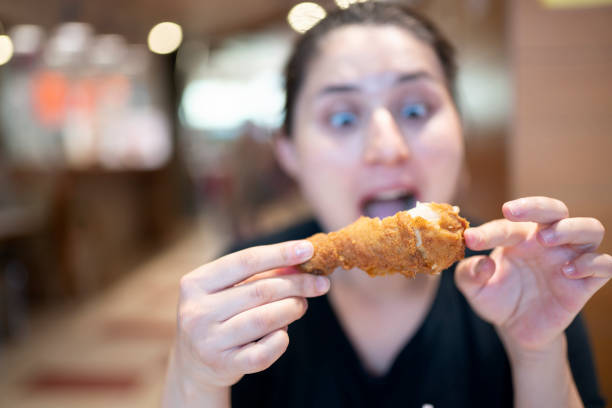 istock Young woman with fried chicken 1182474644