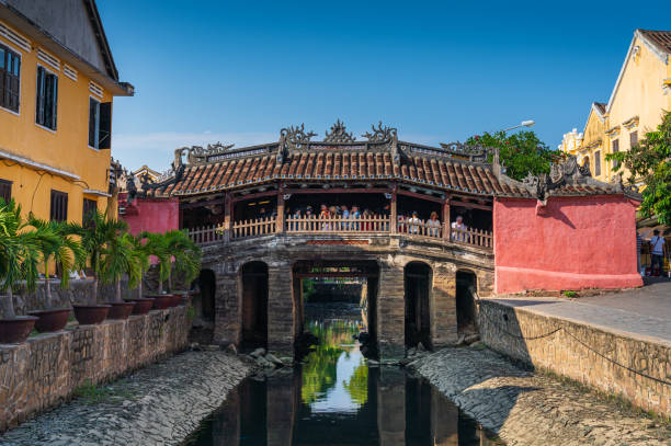 Japanese covered bridge in Hoi An city, Vietnam Hoi An, Vietnam - October 7, 2019 : Tourists visiting the ancient Japanese covered bridge, a famous place in Hoi An, world heritage city in Vietnam. historic heritage square phoenix stock pictures, royalty-free photos & images