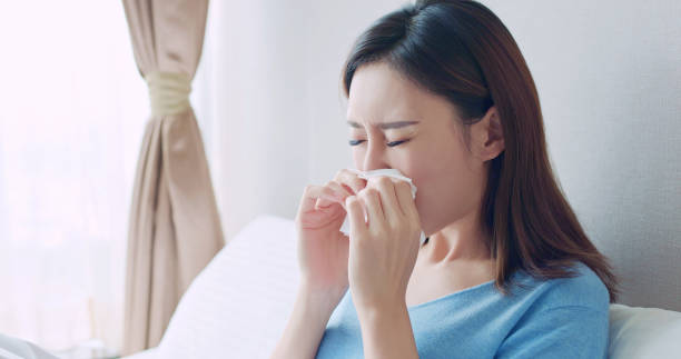 woman sick at home asian woman sick and sneeze with tissue paper in the bedroom bed of hay stock pictures, royalty-free photos & images