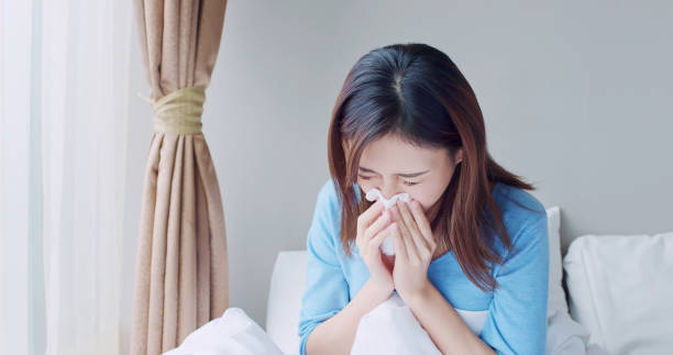 woman sick at home asian woman sick and sneeze with tissue paper in the bedroom bed of hay stock pictures, royalty-free photos & images