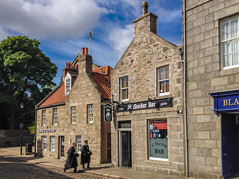 Two graduates entering a bar in the  historic center of Aberdeen, a city with two universities (the ancient University of Aberdeen and the modern Robert Gordon University) located in northeast Scotland.