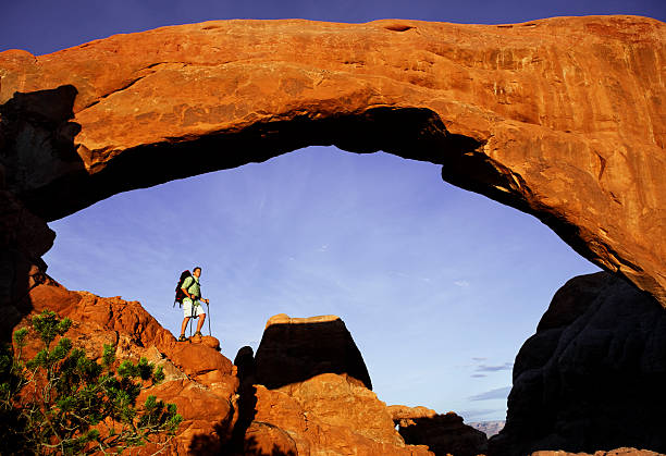 istock Hiker Standing On Massive Rock Under Arch In Utah 118247871