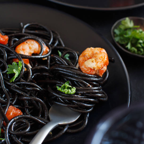 istock Squid ink pasta with prawns and tomatoes 1182479034