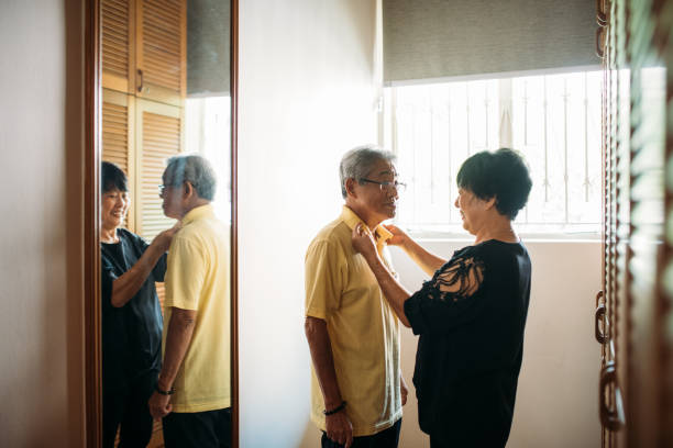 Mature Woman helping her husband to getting dressed