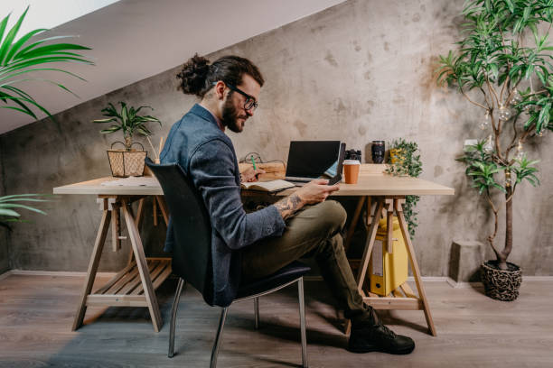 istock Bearded young businessman working at modern office 1182480934