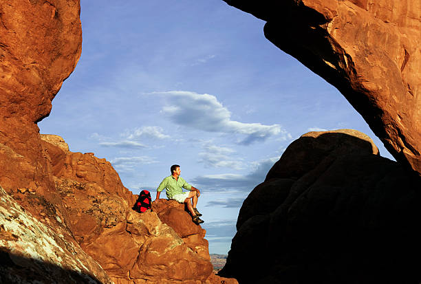 istock Hiker Resting On Rocky Ledge Under Arch In Moab, Utah 118248161