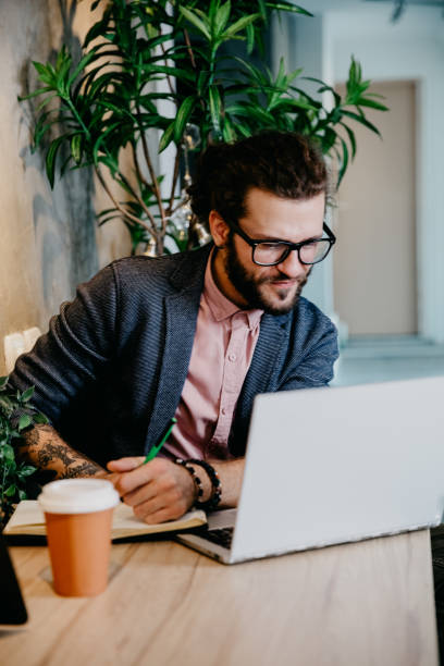 istock Bearded young businessman working at modern office 1182482328