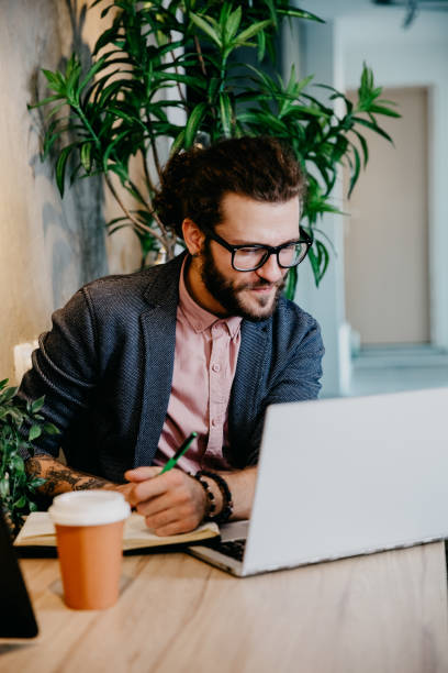 istock Bearded young businessman working at modern office 1182482745