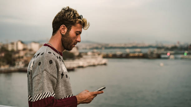istock blond man writing message with mobile phone 1182485051