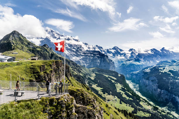 Gondola lift on the Männlichen, between Wengen and Grindelwald, Tschuggen and Lauterbrunnental, Switzerland Wengen, Switzerland - August 14, 2019: Swiss alps, Aerial cableway station on top of the Männlichen between Wengen, Lauterbrunnental and Grindelwald. A swiss flag and some tourists on a viewing platform. swiss flag photos stock pictures, royalty-free photos & images