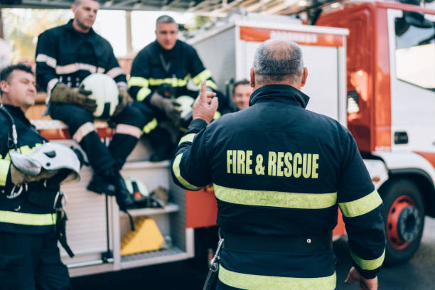 Firefighters on meeting before work Firefighter boss giving team instructions bossy photos stock pictures, royalty-free photos & images