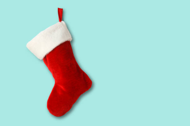 Christmas Stocking On Blue Background A red and white Christmas stocking isolated on a blue background that provides ample room for copy and text. christmas stocking stock pictures, royalty-free photos & images