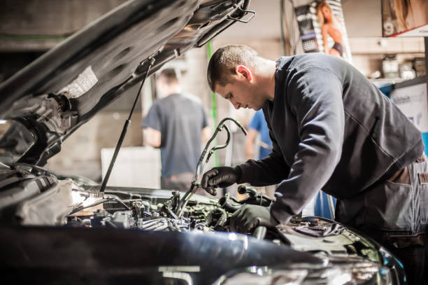 istock Two car mechanic repairers service technician repairs auto engine 1182497525