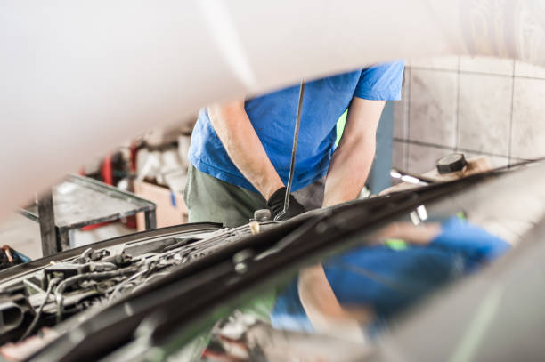 istock Car mechanic repairer service technician checks and repairs auto engine 1182498454