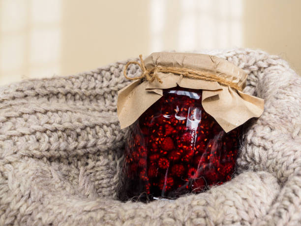 istock A jar of raspberry jam on a wool blanket. Jam jar decorated with Kraft paper. Folk method of treatment 1182498616