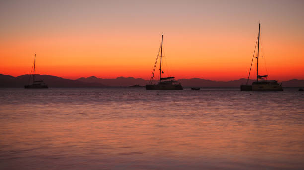 istock Sailing catamaran yachts moored in Datca bay at sunset 1182498795