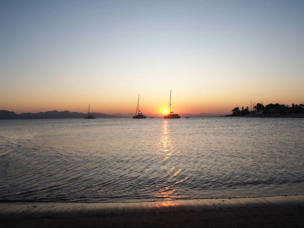istock Sailing catamaran yachts moored in Datca bay at sunset 1182498878