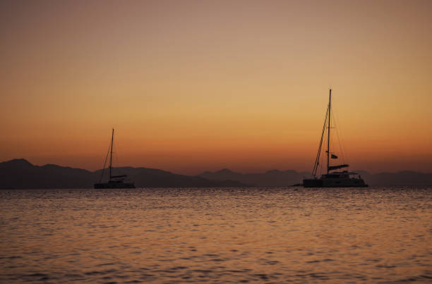istock Sailing catamaran yachts moored in Datca bay at sunset 1182499125