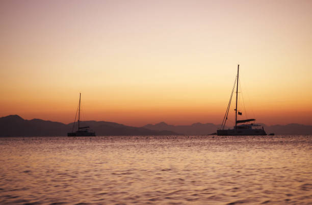istock Sailing catamaran yachts moored in Datca bay at sunset 1182500139