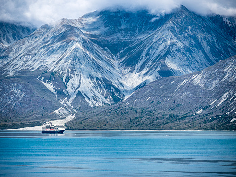 Telephoto view of Holland America Line cruise ship sailing through Alaska’s Glacier Bay National Park in late summer.