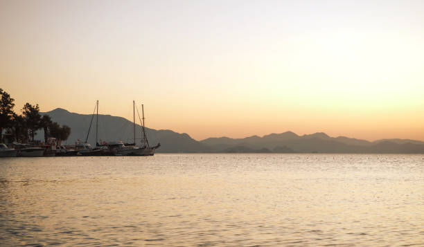 istock Sailing catamaran yachts moored in Datca bay at sunset 1182500395