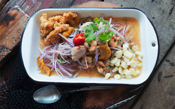 Peruvian ceviche and squid chicharron Peruvian ceviche and squid chicharron served in a plate seviche photos stock pictures, royalty-free photos & images