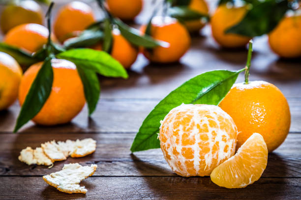 tangerinas orgânicos frescas na tabela de madeira rústica - orange fruit portion multi colored - fotografias e filmes do acervo