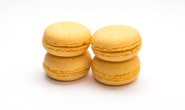 istock four yellow orange macaroons on white isolated background 1182503092