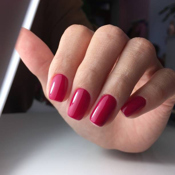 istock Female hands with stylish red manicure on grey background 1182504593