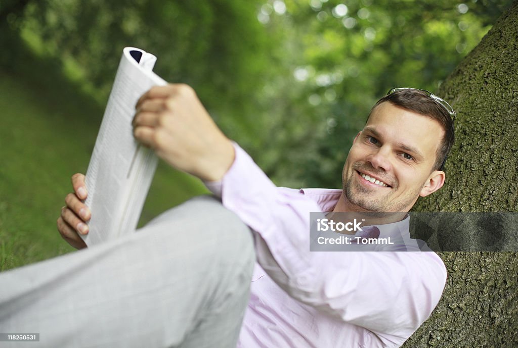 Sonriente joven lectura y - Foto de stock de Leer libre de derechos