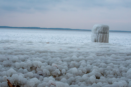 Madison Wisconsin's Lake Mendota ('the big lake') frozen in winter with icy formations covering the grass and a blueish purple sunset
