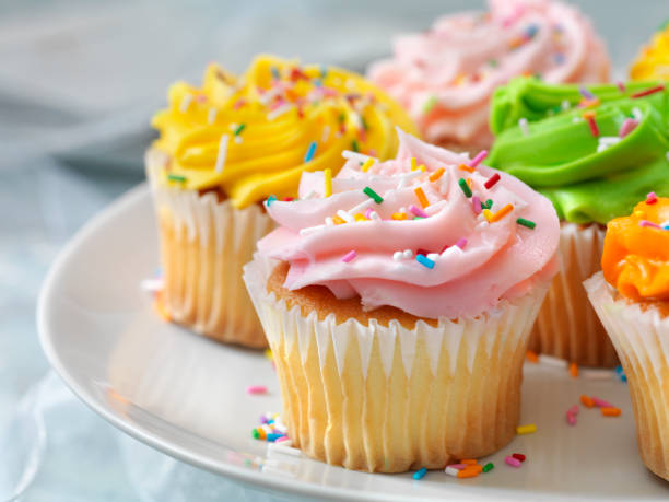 cupcakes coloridos con caramelos - cake server fotografías e imágenes de stock