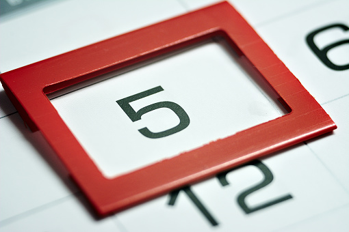 the fifth day of the month highlighted on the calendar with a red frame close-up macro, the mark on the calendar, the fifth date