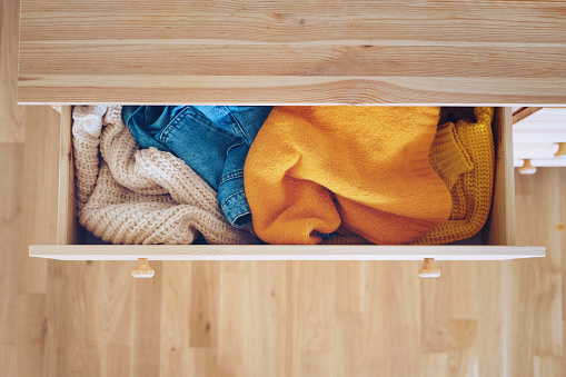 Open drawer with jeans and sweaters