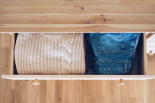 Open drawer with jeans and sweaters
