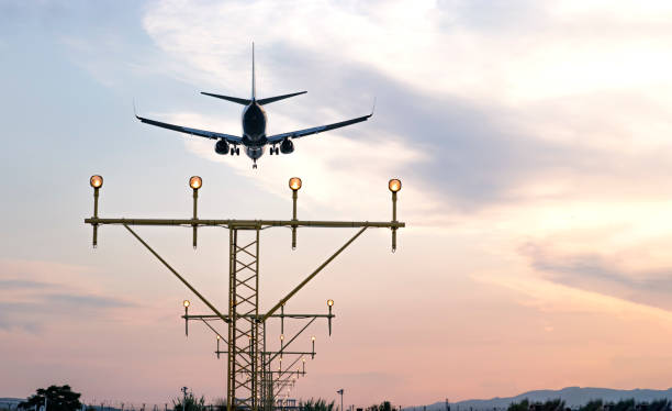 istock Aircraft during the approach procedure at sunset overflying the runway lights 1182511253