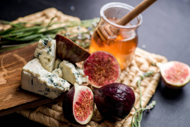 honey, figs and cheese on a wicker plate. Black background honey, figs and cheese on a wicker plate. Black background plate fig blue cheese cheese stock pictures, royalty-free photos & images