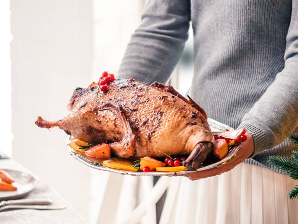 istock roast duck in female hands 1182512692