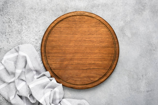 istock Round wooden cutting board on grey concrete background 1182512783