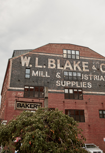 Portland, Maine - September 26th, 2019: Ghost sign of W.L. Blake & Co Mill and Industrial Supplies on exterior of brick building in Old Port district of Portland.