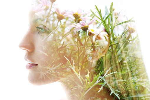 Double exposure woman's closeup portrait with an ecological concept showcasing the beautiful feminine nature of plants and flowers
