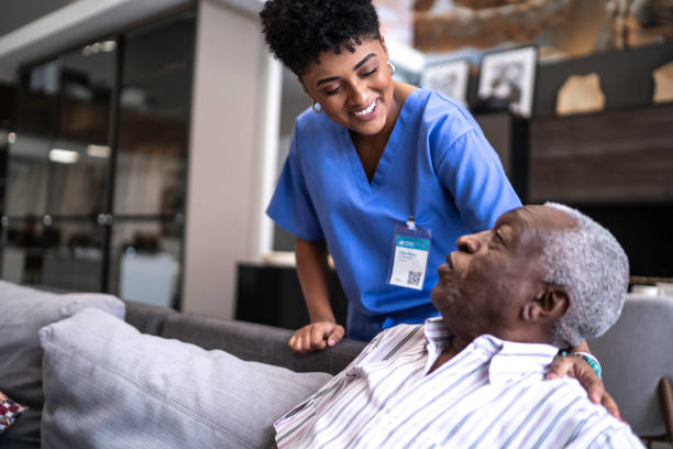Female nurse taking care of a senior man at home Female nurse taking care of a senior man at home home caregiver photos stock pictures, royalty-free photos & images