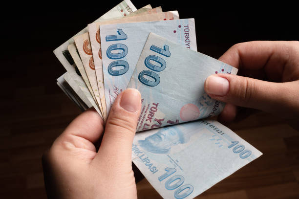 tanınmayan kadın türk banknotlarını sayıyor - para stok fotoğraflar ve resimler