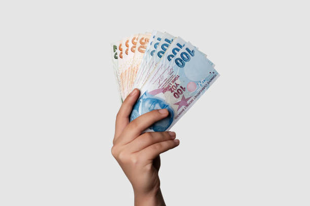 Turkish Lira Unrecognizable person holding Turkish banknotes over gray background. Studio shot. Horizontal composition. lira sign photos stock pictures, royalty-free photos & images
