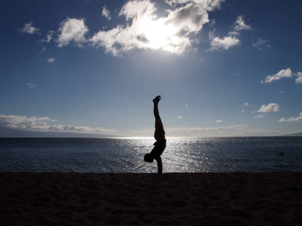 istock Silhouette of Man Handstands at sunset on an empty Beach 1182517171