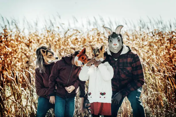 Mixed race family animal masks, during autumn, Quebec, Canada