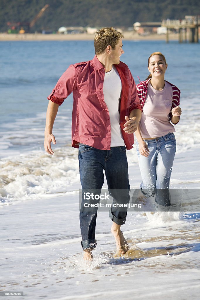 couple running on beach  Adult Stock Photo