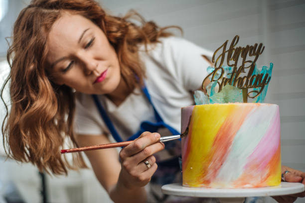 Art has many forms Woman in a  bakery  decorating her cake decorating a cake photos stock pictures, royalty-free photos & images